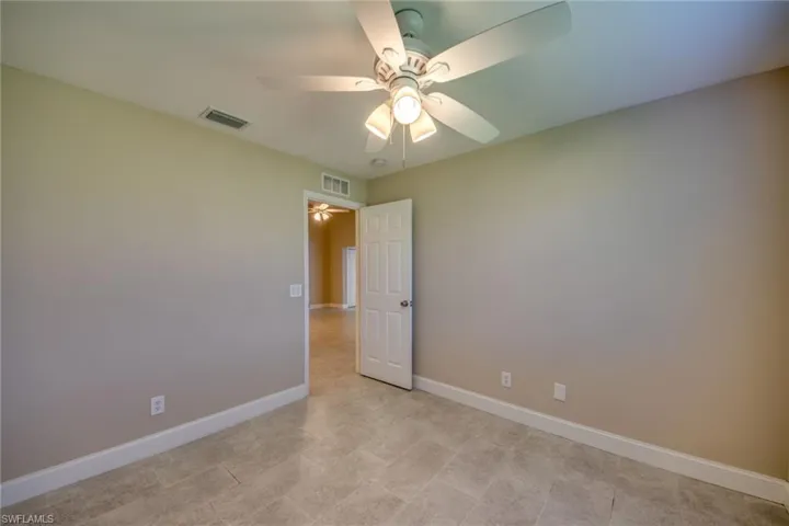 Spare room featuring ceiling fan and light tile patterned floors
