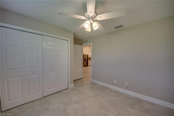 Unfurnished bedroom featuring light tile patterned flooring, a closet, and ceiling fan