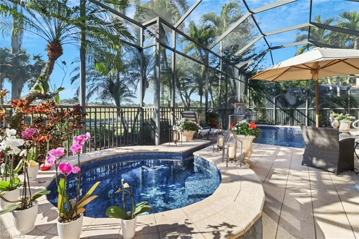 View of pool featuring a patio area, ceiling fan, glass enclosure, and an outdoor living space