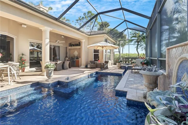 View of pool with pool water feature, a lanai, and a patio area