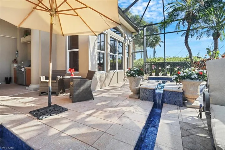 View of patio featuring glass enclosure and ceiling fan