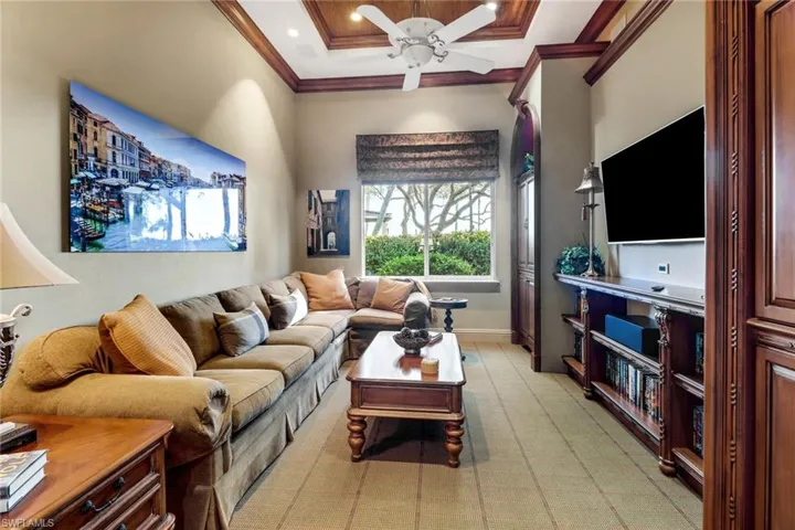 Living room featuring ceiling fan and ornamental molding