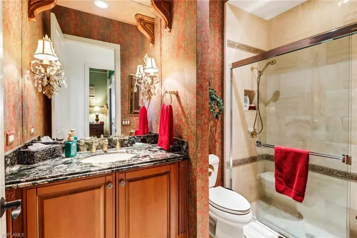 Bathroom featuring ceiling fan, vanity, and toilet