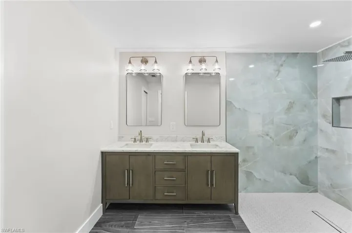 Master Bathroom featuring double vanity and a marble finish shower