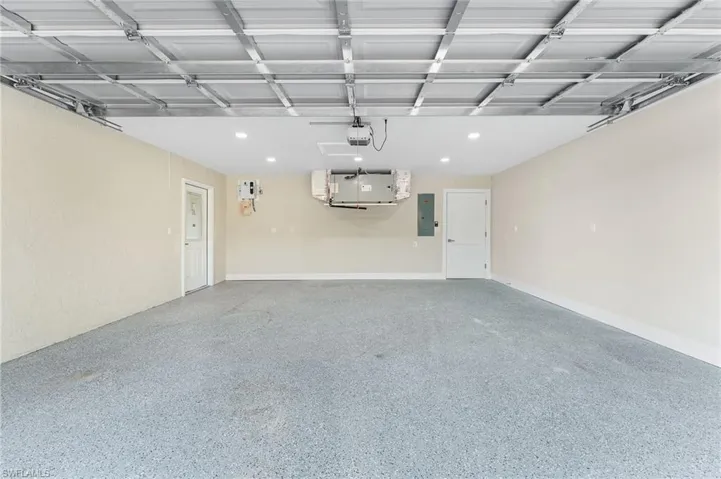 Garage with electric panel, epoxy flooring and a garage door opener.  New Garage door.