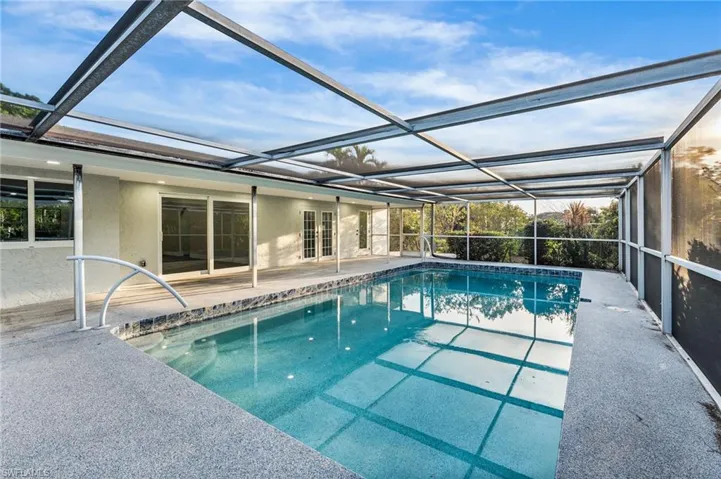 Swimming pool featuring a screen enclosure, and a patio