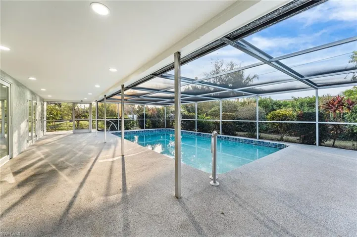 Outdoor pool featuring a sunroom, a lanai, and a patio area