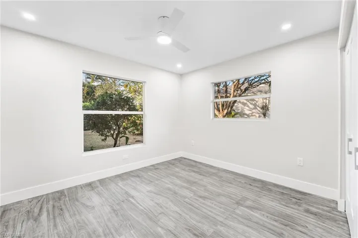 Guest Bedroom with healthy amount of natural light, wood tile finished floors, recessed lighting, and a ceiling fan