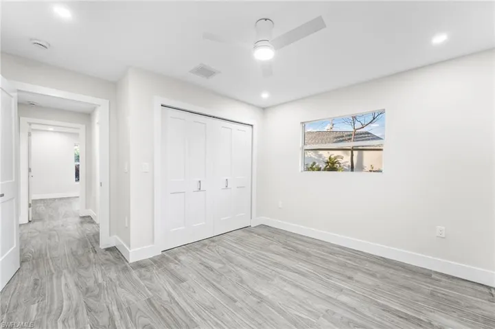 Guest bedroom featuring light wood-type tile flooring, a closet, a ceiling fan, and recessed lighting