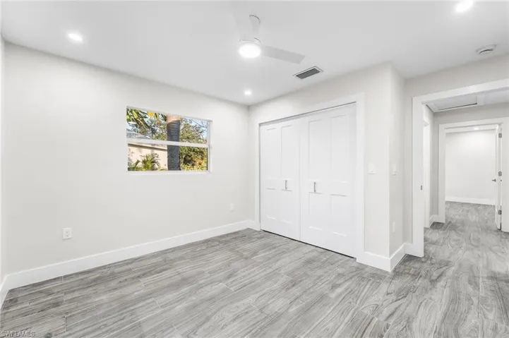 Guest bedroom with a closet, a ceiling fan, light wood-style tile flooring, and recessed lighting