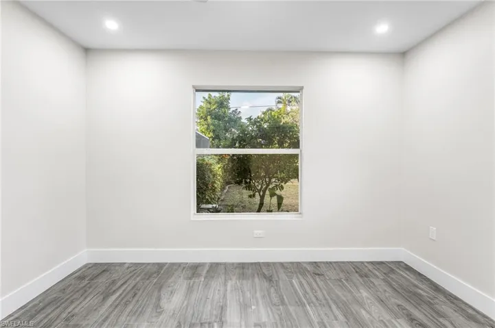 Guest Bedroom with light wood-type tile flooring and recessed lighting
