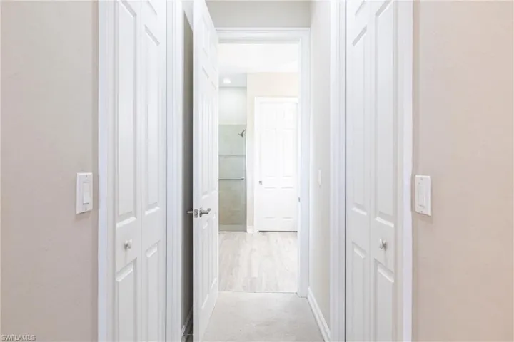 View of hallway with 2 closets leading to bathroom.