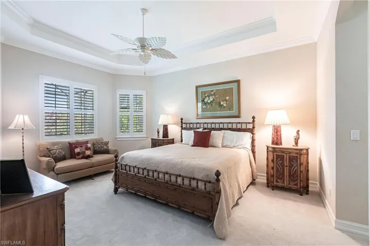 Master bedroom with a seating area, plantation shutters and a great view of Lake.
