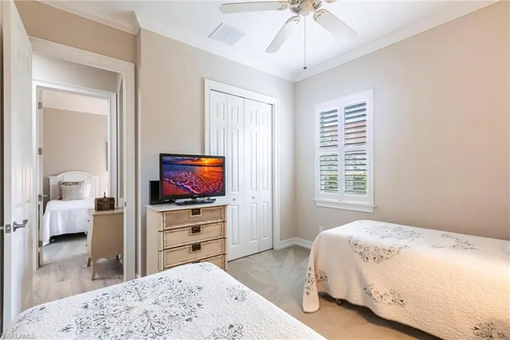 3rd Bedroom with crown molding, ceiling fan, plantation shutters and a large closet.