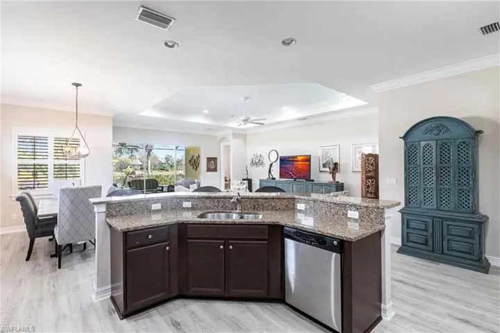 Good view of Kitchen with Dining area to left and Family room to right and Lanai in background.