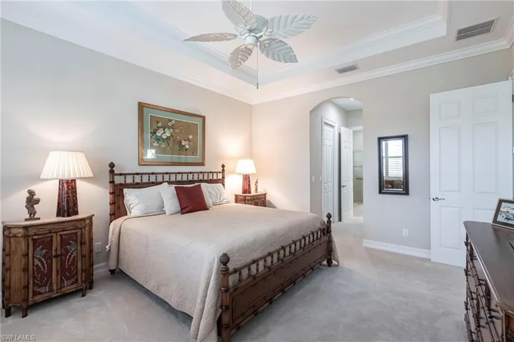 Primary bedroom suite with 2 closets and large bathroom, trey ceiling, ceiling fan and plush carpeting.
