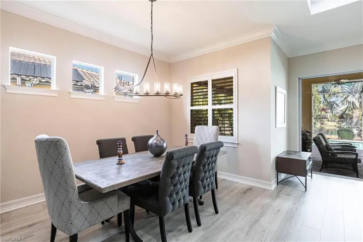 Dining room featuring ornamental molding, a chandelier, and light hardwood / wood-style floors