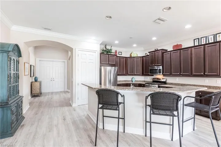Kitchen with stainless steel appliances, granite countertops and a breakfast bar area.