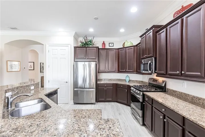 Kitchen featuring light stone countertops adjacent to Family room and dining area.