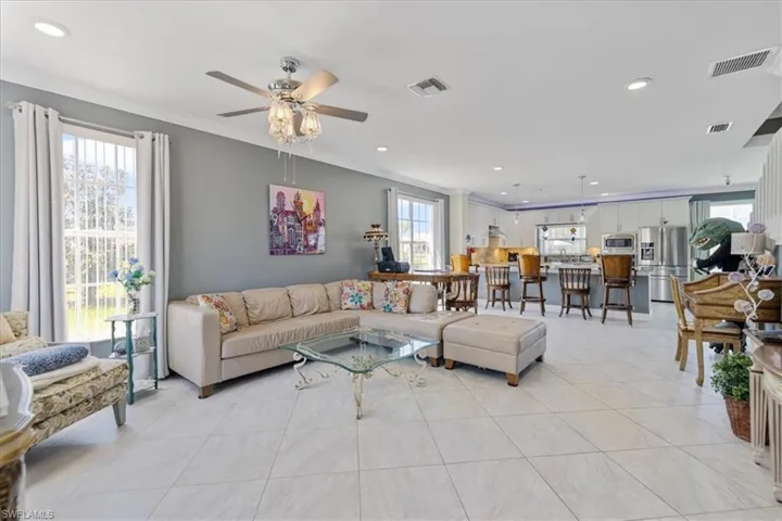 Living room featuring recessed lighting, crown molding, ceiling fan, and visible vents
