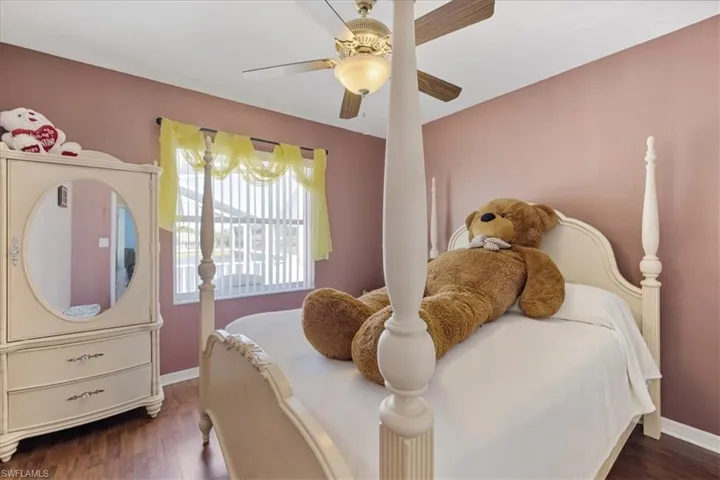 Bedroom featuring baseboards, wood finished floors, and ceiling fan