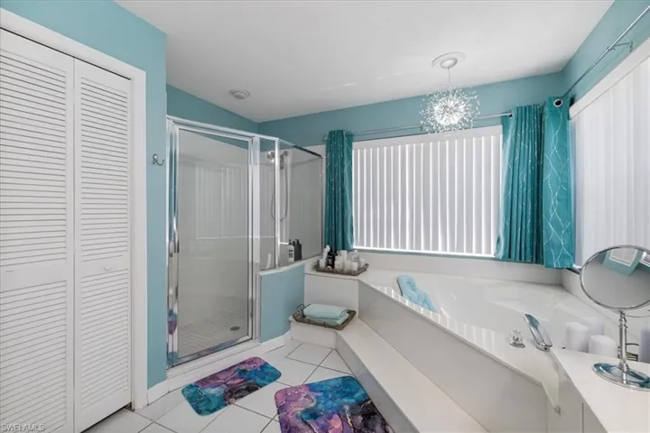 Full bathroom with a closet, a stall shower, tile patterned flooring, and a bath