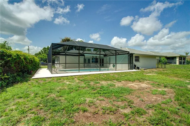 Rear view of house featuring a patio area, an outdoor pool, and glass enclosure