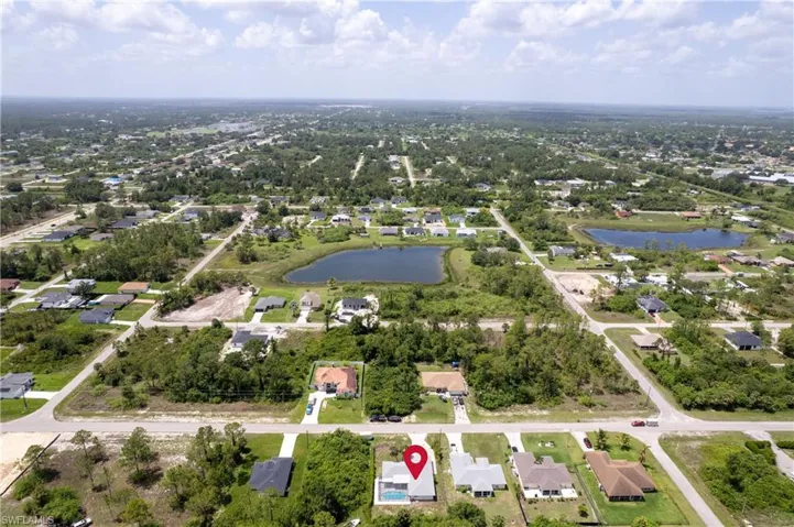 Aerial view of property and surrounding area featuring a large body of water and nearby suburban area