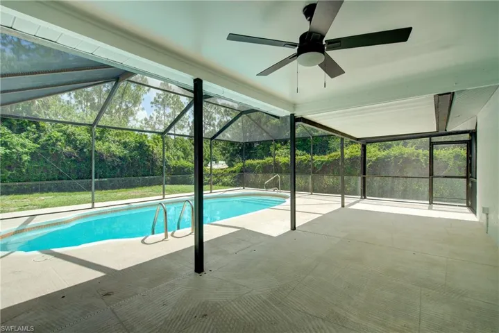 Swimming pool featuring a patio area, ceiling fan, and a lanai