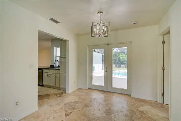Doorway to outside featuring french doors and a chandelier