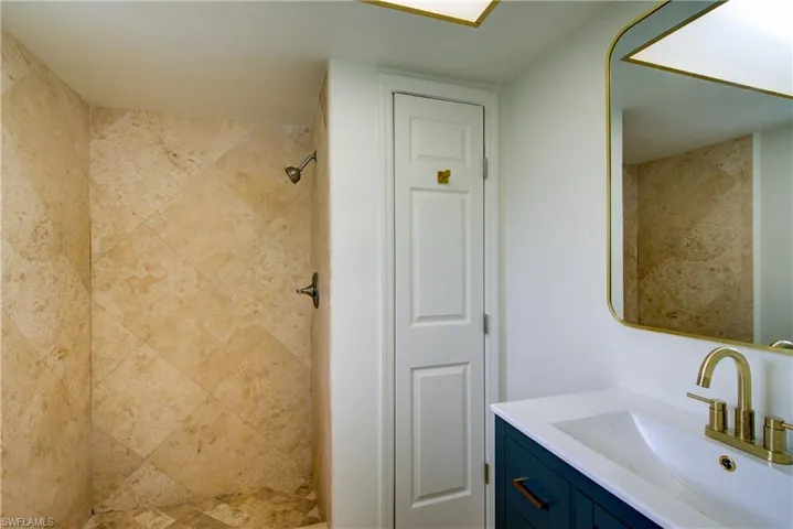 Full bath with vanity and a tile shower