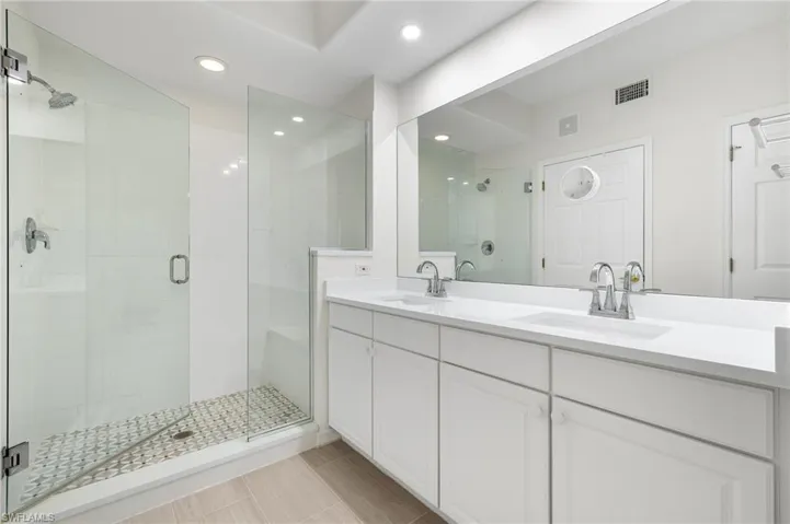 Bathroom with vanity, tile patterned floors, and a shower with shower door
