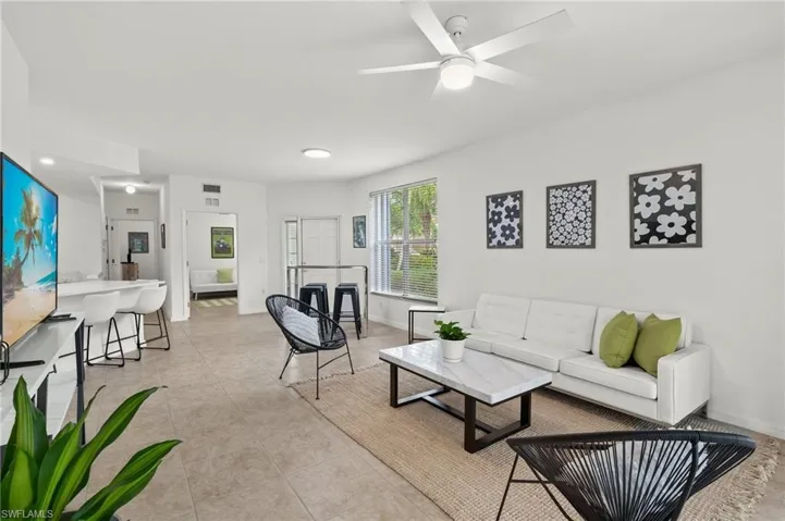 Tiled living room featuring ceiling fan