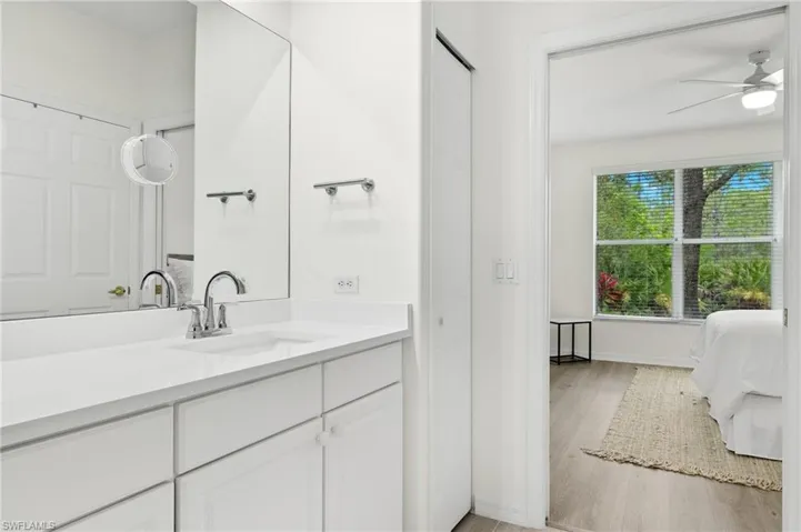 Bathroom featuring hardwood / wood-style flooring, ceiling fan, and vanity