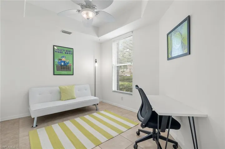 Office space with light tile patterned floors and ceiling fan