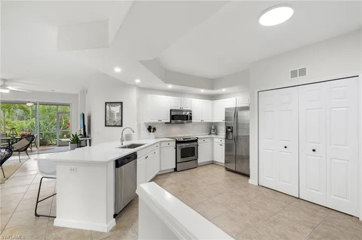 Kitchen featuring stainless steel appliances, sink, a breakfast bar, white cabinets, and kitchen peninsula
