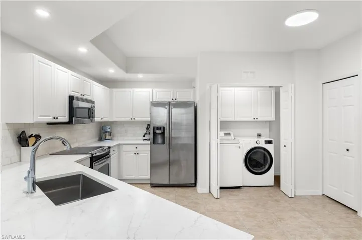 Kitchen with white cabinets, stainless steel appliances, and sink