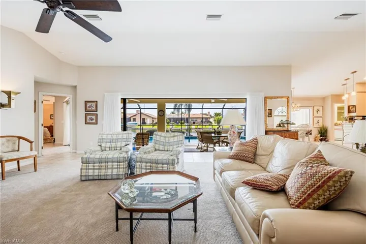 Carpeted living room with ceiling fan