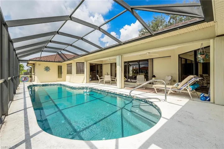 View of pool with ceiling fan, a patio, and a lanai