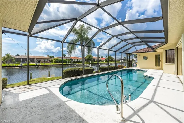View of pool featuring a lanai, a patio, and a water view