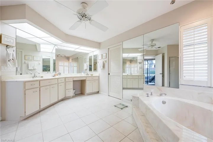 Bathroom featuring ceiling fan, vanity, tile patterned flooring, and independent shower and bath