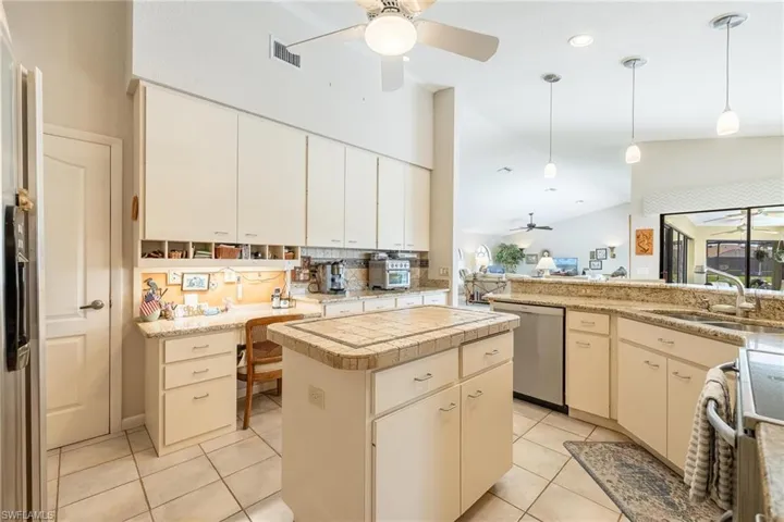 Kitchen with hanging light fixtures, stainless steel dishwasher, a center island, and ceiling fan