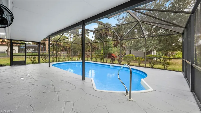 View of swimming pool with a lanai, a sunroom, and a patio