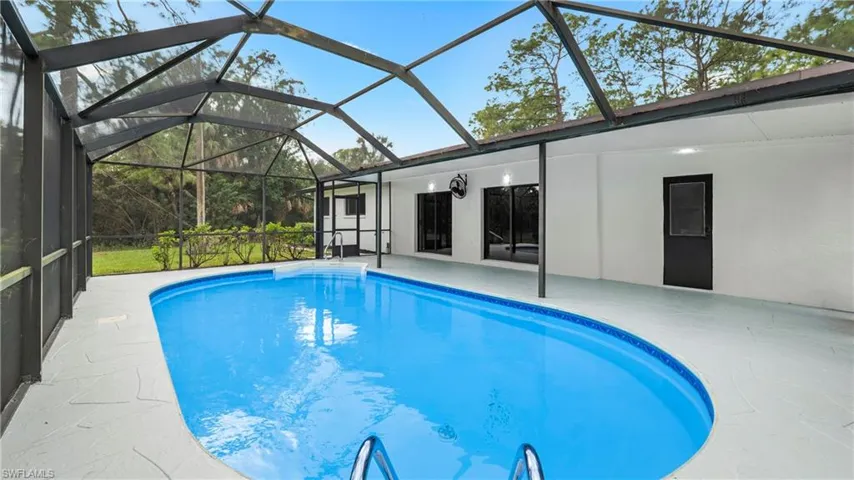 Swimming pool with a lanai, a sunroom, and a patio area