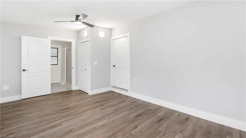 Unfurnished bedroom with wood finished floors, a ceiling fan, and a closet