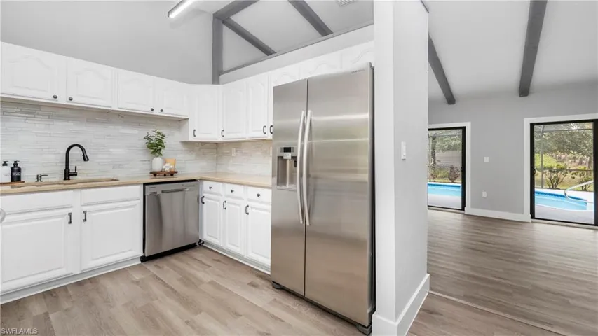 Kitchen featuring stainless steel appliances, light wood-style floors, and white cabinetry