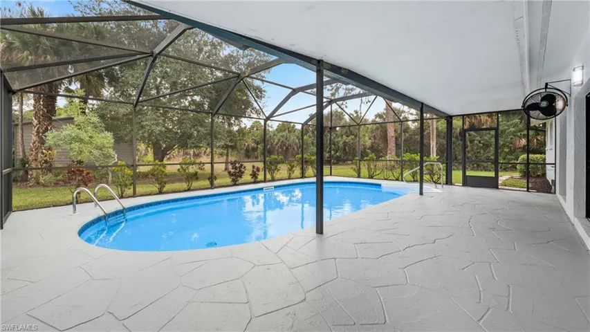 Swimming pool with glass enclosure, a patio, and a sunroom