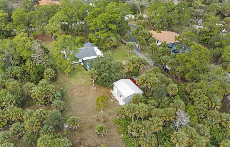 Aerial view of property's location featuring a tree filled landscape