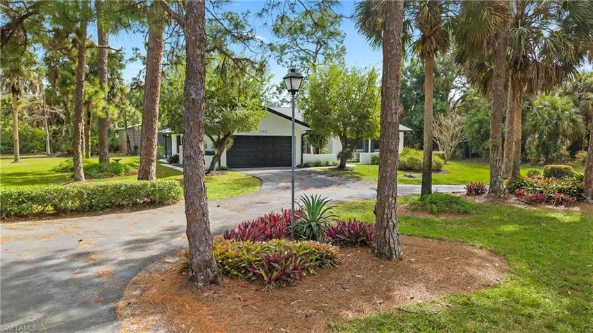 View of front of home with a front yard and asphalt driveway
