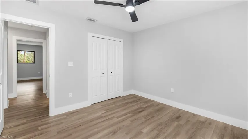 Unfurnished bedroom with light wood-style flooring, a closet, and ceiling fan